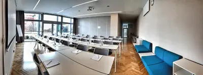 a conference room with tables and blue chairs at Holiday Inn Prague Airport by IHG in Prague