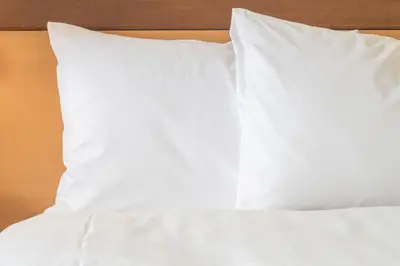a bed with white sheets and pillows on it at Holiday Inn Prague Airport by IHG in Prague