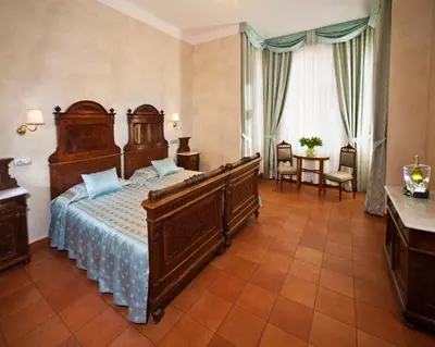 a bedroom with a large wooden bed in a room at Hotel Caesar Prague in Prague