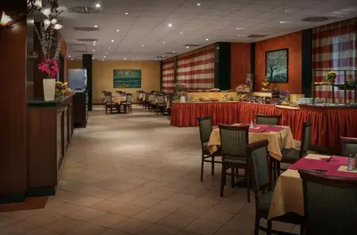 a dining room with tables and chairs in a restaurant at Hotel Caesar Prague in Prague