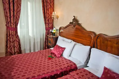 a bedroom with a bed with red and white pillows at Hotel Caesar Prague in Prague