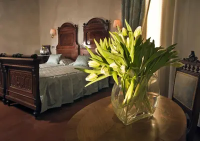 a vase of flowers on a table in a bedroom at Hotel Caesar Prague in Prague