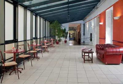 a corridor with tables and chairs in a restaurant at Hotel Caesar Prague in Prague