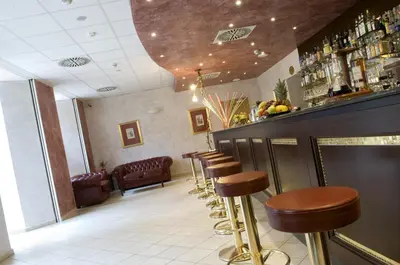 a row of stools at a bar in a restaurant at Hotel Caesar Prague in Prague