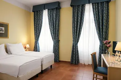 a hotel room with a bed and a desk at Hotel Caesar Prague in Prague