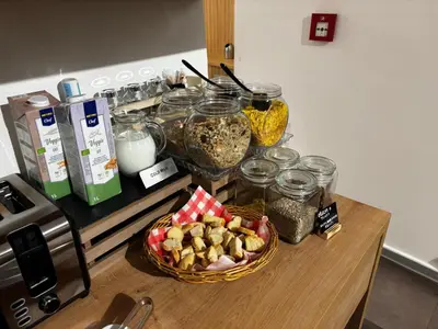 a counter with a bowl of food and jars of food at The Golden Wheel Hotel in Prague