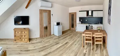 a kitchen and dining room with a wooden table and chairs at Apartmány Statek Bezdědice in Hostomice