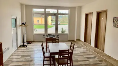 a dining room with a table and chairs and a window at Apartmány Statek Bezdědice in Hostomice
