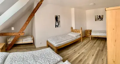a room with three beds and a staircase at Apartmány Statek Bezdědice in Hostomice