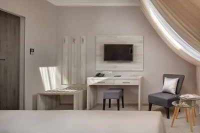 a bedroom with a desk and a tv on a wall at Hotel Florenc in Prague