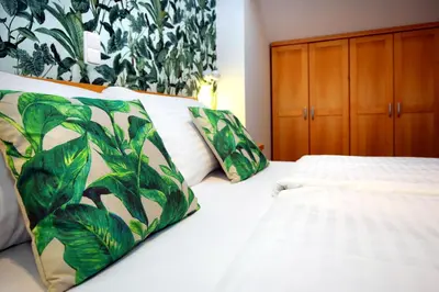a bedroom with two beds with green plants on the wall at Anděl Apartments Praha in Prague