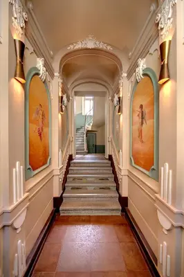 a hallway with stairs and paintings on the walls at Anděl Apartments Praha in Prague