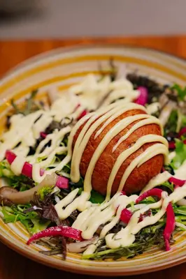 a plate with two pastries with sauce on a salad at Absolutum Wellness Hotel in Prague