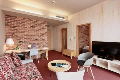 a living room with a couch and a brick wall at Absolutum Wellness Hotel in Prague