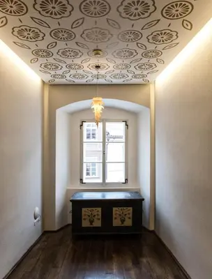 a room with a ceiling with a table and a window at Design Hotel Neruda in Prague