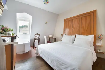 a bedroom with a white bed with a wooden headboard at Design Hotel Neruda in Prague