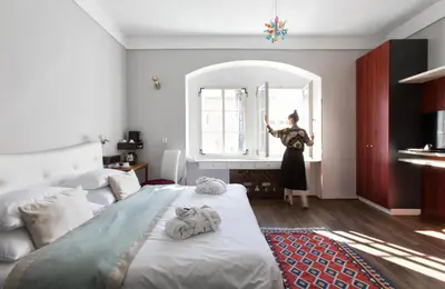 a woman standing in a bedroom looking in a mirror at Design Hotel Neruda in Prague