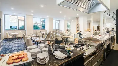 a restaurant with a counter with plates of food at The President in Prague