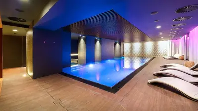 a large swimming pool in a room with purple lighting at The President in Prague