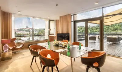a living room with a table and chairs with a view at The President in Prague