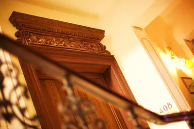 a wooden door in the corner of a room at Louis Leger - Czech Leading Hotels in Prague