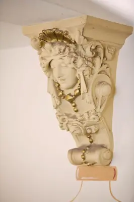 a white statue with a gold chain hanging from a wall at Louis Leger - Czech Leading Hotels in Prague
