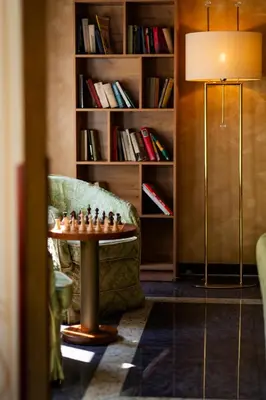 a living room with a table and a chair and a lamp at Louis Leger - Czech Leading Hotels in Prague