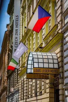 a sign for a louisvelt hotel with flags on a building at Louis Leger - Czech Leading Hotels in Prague