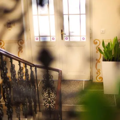 a person walking down a staircase with two doors at Louis Leger - Czech Leading Hotels in Prague