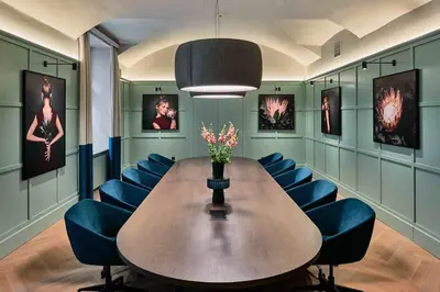 a conference room with a wooden table and blue chairs at Falkensteiner Boutique Hotel Prague in Prague