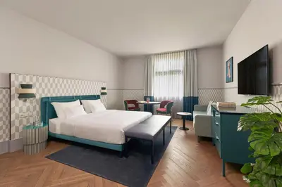 a hotel room with a bed and a tv at Falkensteiner Boutique Hotel Prague in Prague