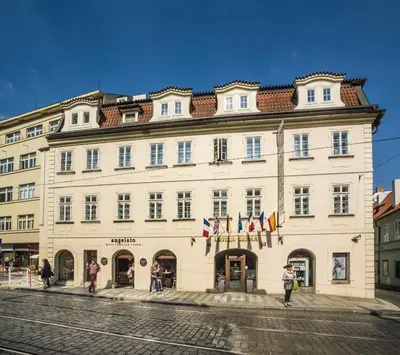 a large white building with flags in front of it at Hotel Roma Prague in Prague