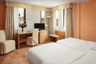 a hotel room with a bed and a desk with a computer at Hotel Roma Prague in Prague