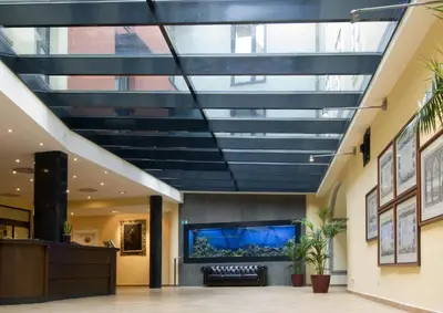 a glass ceiling in a lobby with a large aquarium at Hotel Roma Prague in Prague