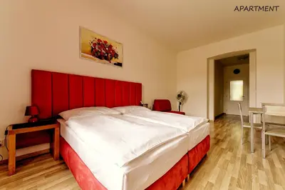 a bedroom with a large bed with a red headboard at Hotel Otakar in Prague