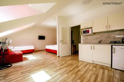 a large room with two beds and a kitchen at Hotel Otakar in Prague