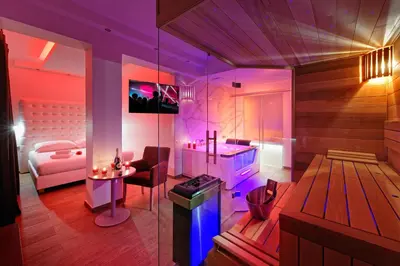 a room with a bedroom with a bed and a table at Hotel Aura Design & Garden Pool in Prague