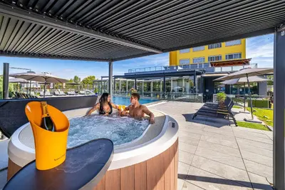 two people in a jacuzzi in a swimming pool at Hotel Aura Design & Garden Pool in Prague