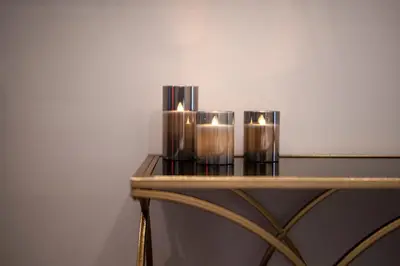 a group of three candles on a table at Hotel Aura Design & Garden Pool in Prague