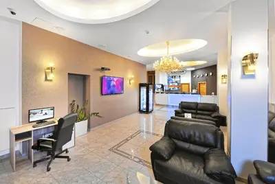 a waiting room with leather chairs and a desk at Hotel Aura Design & Garden Pool in Prague