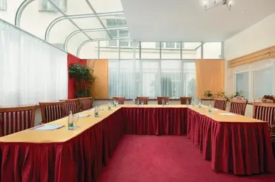 a conference room with tables and chairs and a screen at Ramada Prague City Centre in Prague