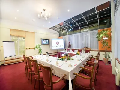 a kitchen with wooden cabinets and a couch in a room at Ramada Prague City Centre in Prague