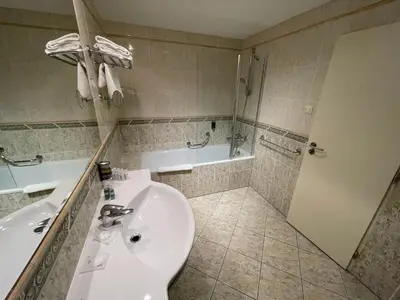 a bedroom with a bed and a desk and a mirror at Ramada Prague City Centre in Prague