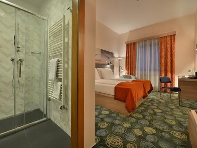 a hotel room with a bed and a shower at Ramada Airport Hotel Prague in Prague