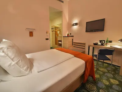 a hotel room with a bed and a desk at Ramada Airport Hotel Prague in Prague