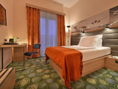 a hotel room with a bed and a desk at Ramada Airport Hotel Prague in Prague