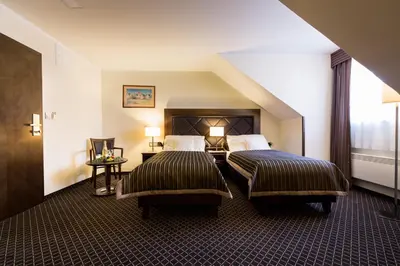 a hotel room with two beds and a window at Hotel Selsky Dvur - Bohemian Village Courtyard in Prague