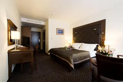 a hotel room with a large bed and a desk and a bed sidx sidx sidx at Hotel Selsky Dvur - Bohemian Village Courtyard in Prague