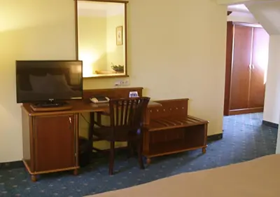 a room with a desk with a computer and a television at Hotel Selsky Dvur - Bohemian Village Courtyard in Prague