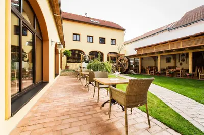 a patio with a wooden table and chairs at Hotel Selsky Dvur - Bohemian Village Courtyard in Prague